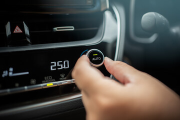 Driver adjusting car air conditioner system at interior panel