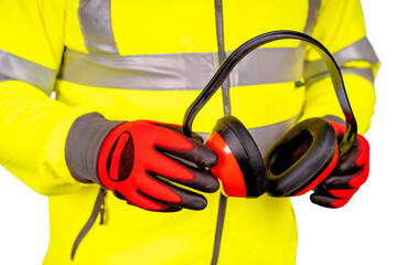 A builder in bright yellow reflective hi-visibility fleece and safety gloves holding ear defenders...