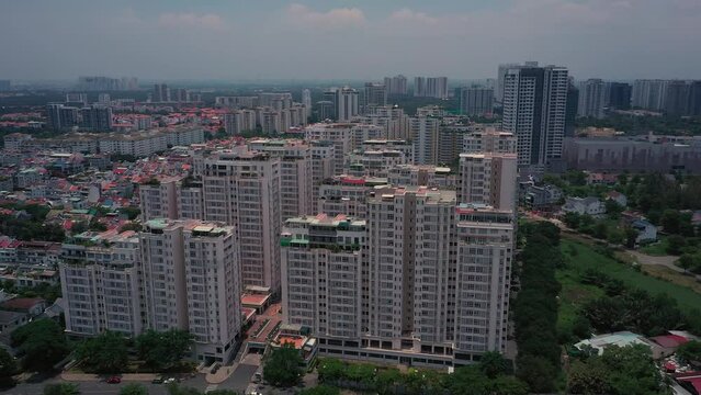 Aerial suburban view on sunny day with large apartment and housing development on river. Counter clockwise orbit of condominium.