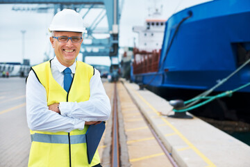 Industrial worker working on a shipping port to export stock, containers and packages. Portrait of...