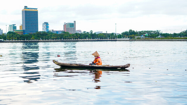 A fisherman enjoys the view of the city from a boat in the sea