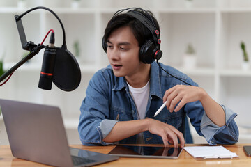 Asian podcaster making audio podcast working at home studio