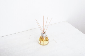 Aromatic incense, oil diffuser with reed sticks on white table. Isometric projection, copy space