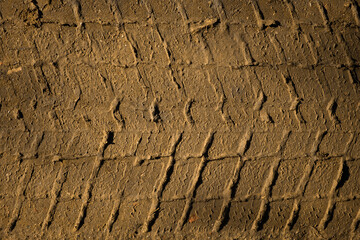 The texture of the track car. Brown earth close-up view from above. Natural design. Tire tracks on...