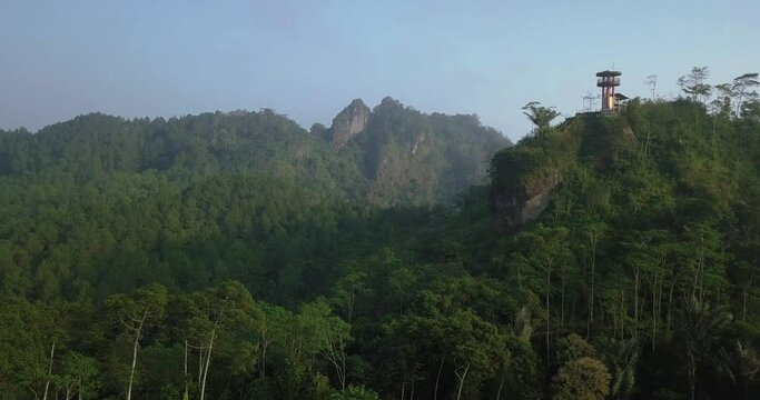 Aerial view of forest and hills with fog between in the morning in Indonesia