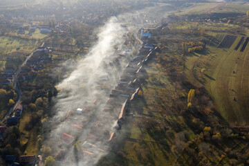Aerial drone view of morning haze and mist above village houses
