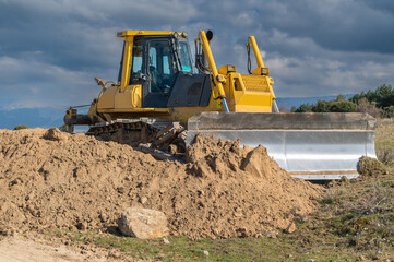 Obraz premium Excavator moving dirt and sand at a construction site