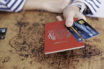 Hand with passport and credit card. Holiday travel concept.Credit card with passport and world map
