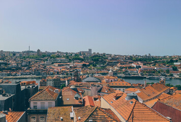 Fototapeta na wymiar Orange roofs on high part of the city with different antique architecture and city in front