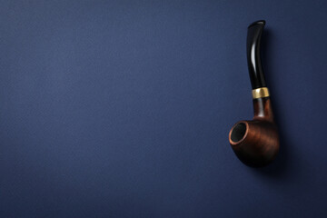 Smoking pipe on blue background, space for text