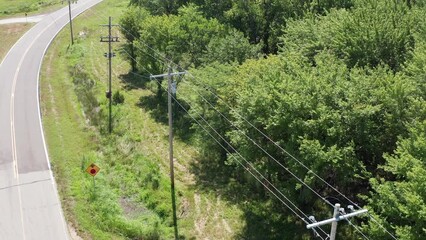 Close-up aerial shot flying over a rural utility pole and powerline inspection. 4K