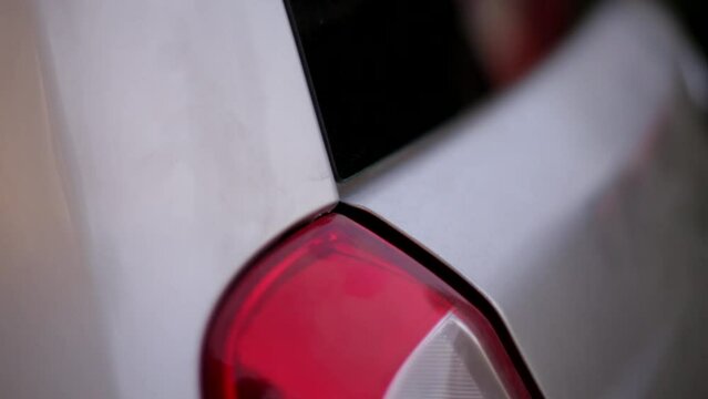 Shutting rear door of damaged car trunk manually macro shot 