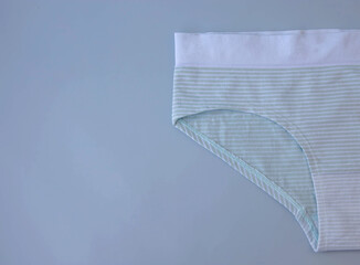 Template place for the text blank green women's cotton underpants lie on a blue background