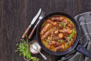 german beef rouladen in thick gravy on pan