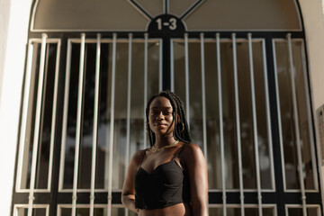 Portrait of a young black female posing in front of a doorway during a modeling session at sunset