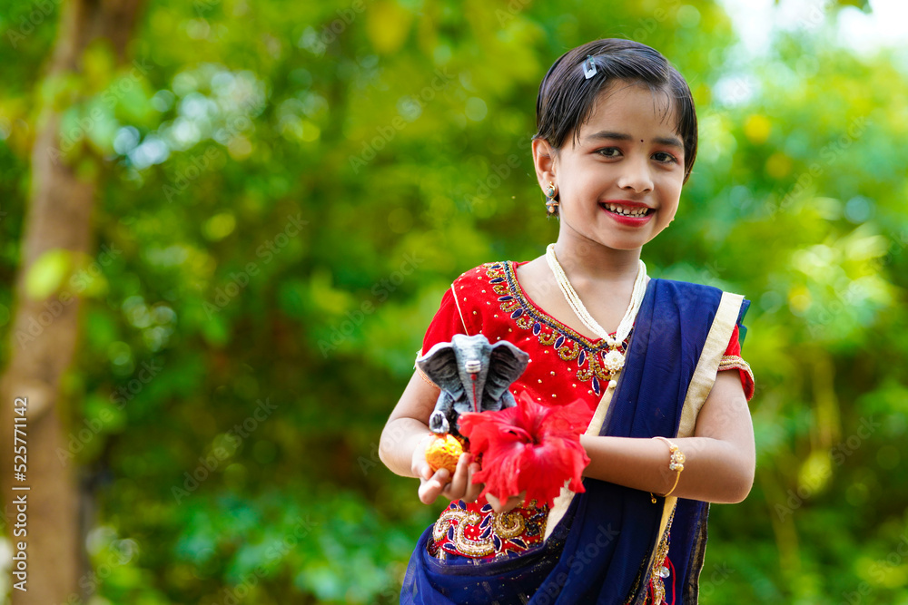 Wall mural cute indian little girl celebrating lord ganesha festival.