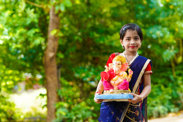 Cute indian little girl celebrating lord ganesha festival.