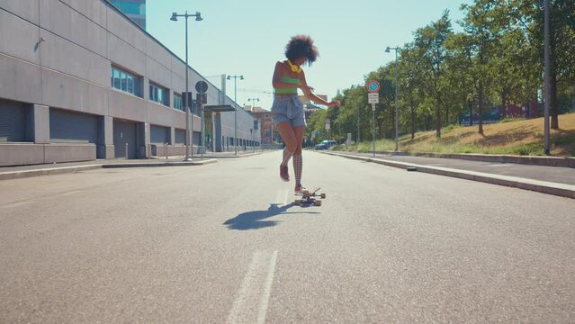 Beautiful young woman cruising around the city with her longboard.  Female teenager practicing longboard dance discipline. Concept about sport and lifestyle