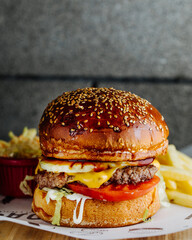 Burger with tomatoes and fries
gray background