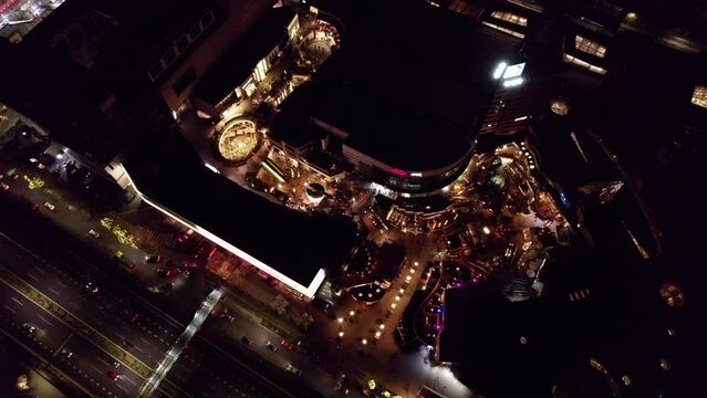 Aerial top down orbit of Parque Arauco luxurious Shopping Mall illuminated at night, Las Condes, Santiago, Chile