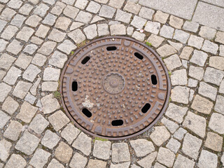 Metal hatch on paving stones.