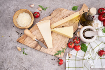 Parmesan cheese and knife on a wooden cutting board