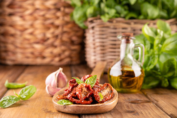 Dried tomatoes with herbs and olive oil. Traditional canned tomatoes in Italy with garlic, Provence herbs and basil. Ingredients for bruschetta and aperitif. Top view, space for text