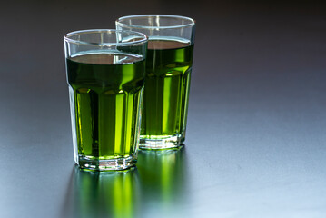 Lemon mint iced green tea cocktail refreshing drink for summer days two glass herbal dark background.