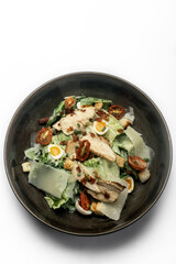 fresh caesar salad in bowl on white background