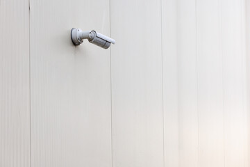 Outdoor surveillance camera on the white wall of the building.
