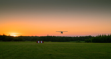 Fototapeta na wymiar ultralight aircraft landing in the evening