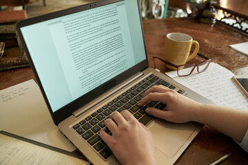 Modern writer writing a novel on a laptop - obrazy, fototapety, plakaty