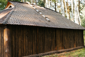 Naklejka premium Exterior rustic barn made of planks in the woods outdoors. Close-up, side view