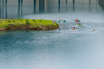 エメラルドグリーンの奥四万湖に浮かぶカヌーを楽しむ人々