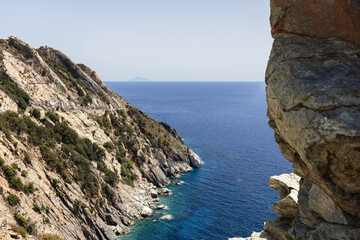 Narrow bay in the rift of the mountains with road running high along the cliff, Province of Livorno, Island of Elba, Italy