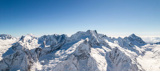 Fototapeta na wymiar Mountain peaks covered in snow under a clear blue sky 