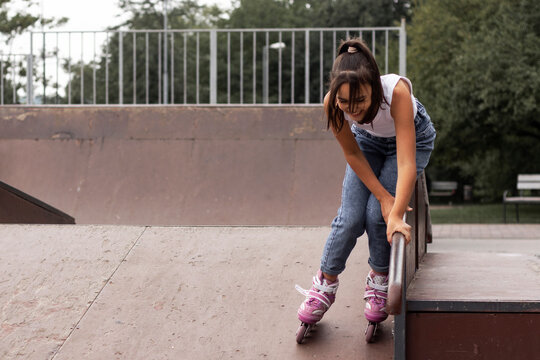 Portrait of a girl learning to inline skates on the playground.