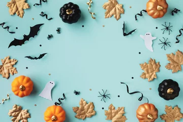 Keuken spatwand met foto Halloween holiday frame with party decorations of pumpkins, bats, ghosts, spiders on blue background top view. Happy halloween card in flat lay style. © juliasudnitskaya