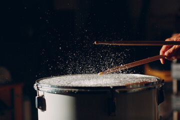 Close up drum sticks drumming hit beat rhythm on drum surface with splash water drops