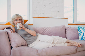 Elderly caucasian old aged woman drinking enjoying afternoon tea at home