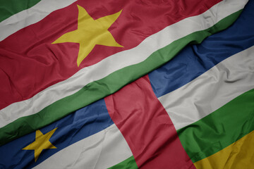 waving colorful flag of central african republic and national flag of suriname.