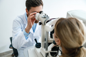 Optometrist checks the patient's intraocular pressure in optician's shop or ophthalmology clinic