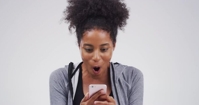 Wow, surprise woman on phone winning online competition or a sale notification on social media in studio. Happy black woman with smartphone in hand reading marketing email or newsletter announcement