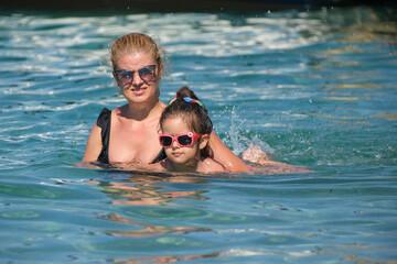 Mother teaching daughter to swim