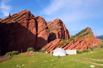 Jeti-Öguz Rocks In Kyrgyzstan. Jety-Oguz gorge Canyon, cliffs of seven bulls. White yurt standing...