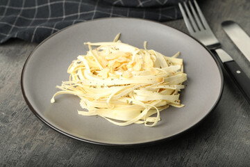 Fresh white carrot salad served on grey table, closeup