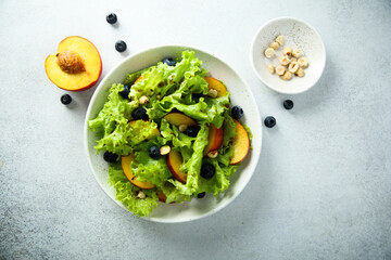 Healthy leaf salad with peach and blueberry