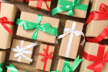 Christmas gift boxes with bows on wooden background, flat lay
