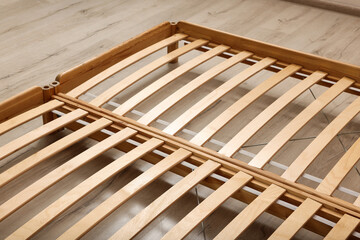 Obraz premium Wooden bed frame on floor, closeup view