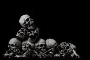 Awesome pile of skull human and bone on wooden, black cloth background, concept of scary crime...